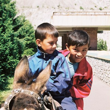 Photo of Boys riding a donkey in Medeu Mountains, Kazakhstan - Central Asia