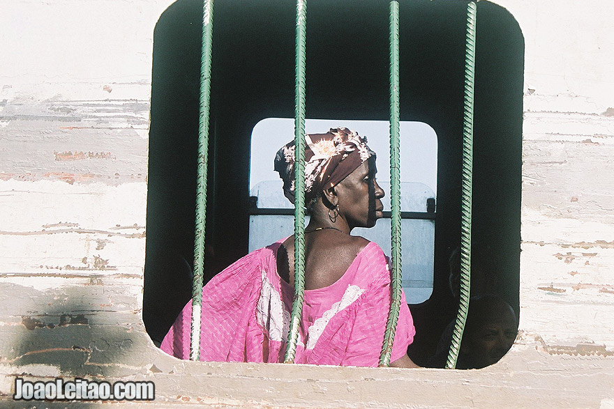 Photo of Woman looking out the window in ferry-boat from Banjul to Barra, The Gambia West Africa